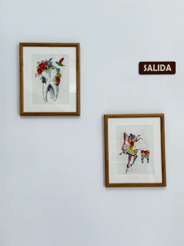 Ilustraciones enmarcadas de dientes en una pared de la clínica
